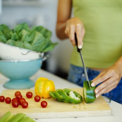 mid section view of a woman cutting vegetables