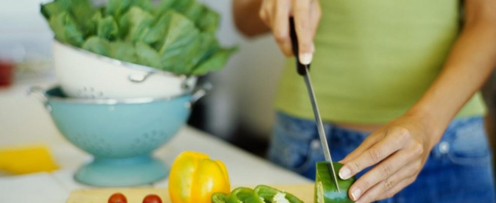 mid section view of a woman cutting vegetables